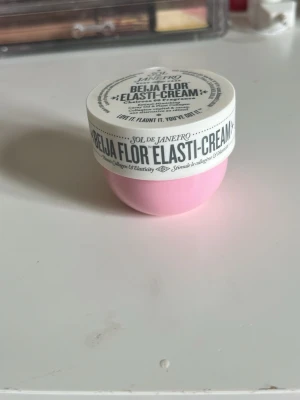 Sol de Janeiro Beija Flor Elasti-Cream - Beija Flor Elasti-Cream från Sol de Janeiro i en liten rosa burk med vitt lock. Krämen är vit och har en rik, krämig konsistens. Liten Bum Bum cream från sol de Janeiro doft 68. 