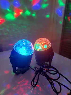 Färgglada LED discobollar med sladd - Två discobollar med LED-belysning som skiftar färg i blått, rött, grönt och lila. Bollarna har en kupolformad yta i plast med hexagonmönster och svart bas med monteringsfäste. Perfekt för att skapa coola ljuseffekter i rummet. Drivs med sladd.