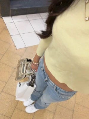 Ljusgul stickad tröja  - Söt ljusgul stickad tröja från Carin Wester med rund halsringning och långa ärmar. Tröjan har en croppad passform och ribbade muddar vid ärmslut och nederkant. Perfekt att styla med jeans för en fräsch vardagslook.
