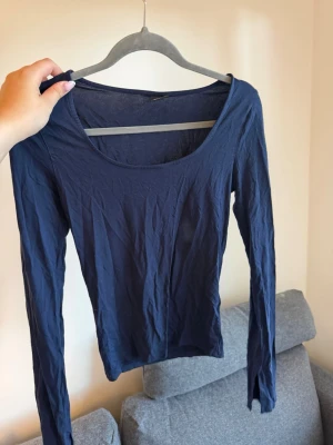 Mörkblå långärmad topp - En enkel och stilren mörkblå långärmad topp med rund halsringning. Tillverkad i mjukt och tunt matris. Perfekt att matcha med jeans eller kjol.