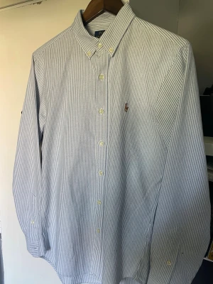  Polo Ralph Lauren skjorta Oxford modell M - Säljer denna helt nya blåvit-randig skjorta från Polo Ralph Lauren Oxford modell Storlek M Material: 100 % bomull  Orginalpris: 1995 kr 