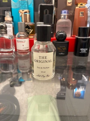 The Original Eau de Parfum 50 ml - En stilren parfymflaska i genomskinligt glas med svart skruvkork. Etiketten är vit med svart text och flaskan rymmer 50 ml Eau de Parfum från märket All Cap One. Enkel och klassisk design som passar perfekt i badrumshyllan. Hälften kvar😊🙌