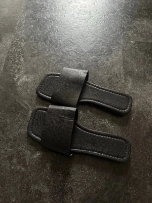 Svarta slides med bred rem - Stilrena svarta sandaler med bred rem över foten och fyrkantig sula. Storlek 36, aldrig använda!