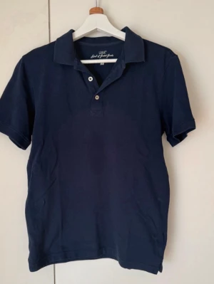 Mörkblå pikétröja med krage - En klassisk mörkblå pikétröja från H&M. 