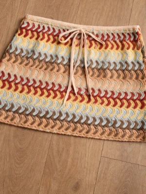 Stickad kortkjol med snörning - Superfin stickad kortkjol med vågigt mönster i beige, brunt, ljusblått, gult och rött. Kjolen har snörning i midjan och är perfekt för dig som gillar retrovibbar och färg. Materialet är mjukt och känns skönt mot huden.