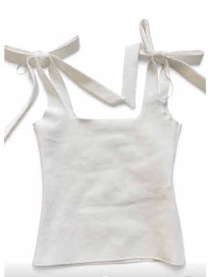 Vit linnetopp med knytband - Supersöt vit linnetopp med breda axelband som knyts till rosetter på axlarna. Toppen har en rak, croppad passform och är ärmlös. Från Zara i stolek XS.