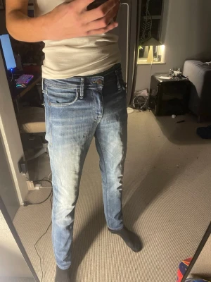 Ljusblå jeans jack&jones - Säljer ett par ljusblå slim fit jeans med klassisk femficksdesign och snygga slitningar framtill. Jeansen har normal midja och dragkedjegylf. Perfekta för dig som gillar en avslappnad men ändå stilren look. Från jack&jones
