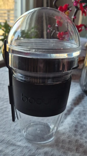 Yoghurtbägare/mugg med sked från Bodum - Säljer 4 genomskinlig yoghurtbägare från Bodum (Bodum Yoghurtkrukor JOYCUP 0.25 L) med svart silikonband och tillhörande sked. Perfekt för att ta med frukost eller mellanmål. Bägaren har rundad form och ett lock i plast som håller innehållet fräscht. Två sista bilderna lånade feån Elgiganten.
