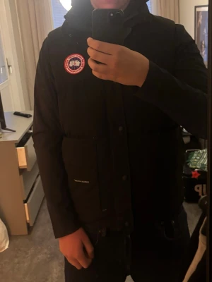 Svart dunväst från Canada Goose - Snygg svart dunväst från Canada Goose med klassisk logotyp på bröstet. Kom gärna privat för mer bilder