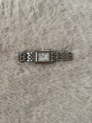 Silverfärgad rektangulär klocka - Stilren klocka i silverfärg med rektangulärt ur och länkarmband. Urtavlan har romerska siffror och en klassisk design som passar till många olika stilar. Perfekt accessoar för dig som gillar tidlös elegans.