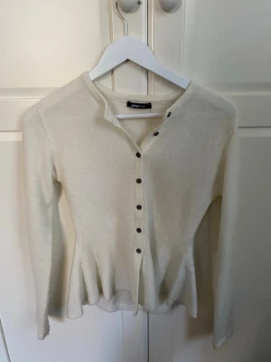 Vit kofta från Gina Tricot - Säljer en enkel och stilren vit kofta från Gina Tricot. Koftan har långa ärmar, rund halsringning och knappar framtill. Aldrig använt. Skriv ifall du har några frågor🩷🩷