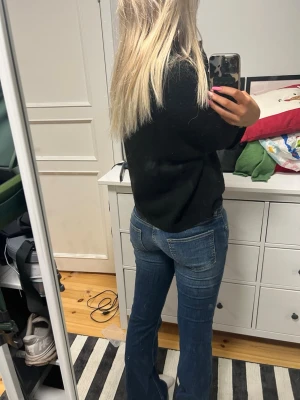 Blå bootcut jeans med låg midja - Säljer ett par blå bootcut jeans med låg midja och klassiska fem fickor. Jeansen har snygga slitningar och kontrastsömmar. Perfekta för dig som gillar en retro vibe och vill ha ett par jeans som sitter tajt upptill och har utsvängda ben. Säljer på grund av att jag är inte största fanet av lågmidjade jeans! Och har aldrig använt dom. 
