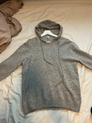 Grå hoodie från Garde Risch - Mysig grå hoodie från Garde Risch i storlek M. Tillverkad 100% Marinull. Litet slitage framtill som man ser på bild nummer två. Därav priset är lägre. 