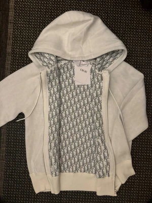 D Hoodie - En helt ny D Hoodie med bra tyg kvalité och riktigt snygga detaljer, lappen finns ej kvar då den användes en gång. För liten för mig men mycket fräsch.