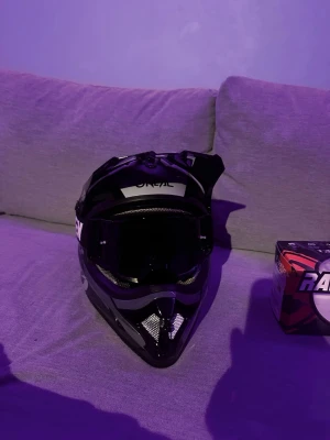 Svart crosshjälm O'Neal med goggles - Säljer en svart crosshjälm från O'Neal med cool design och robust form. Hjälmen har ventilationsnät framtill och kommer med svarta Raven Sniper-goggles. Perfekt för motocross eller enduro. Materialet är hårdplast med vadderad insida för extra komfort.     skit snygg hjälm, köptes in för 2199kr säljes för 1149kr prutat och klart.