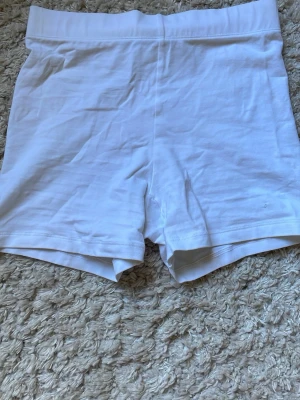 Vita cykelshorts från BikBok - Säljer ett par vita cykelshorts från BikBok i storlek XS. De har en hög midja och är gjorda i mjuk och stretchig bomull, perfekta för en avslappnad och sportig look. Passar till allt och är superbekväma!