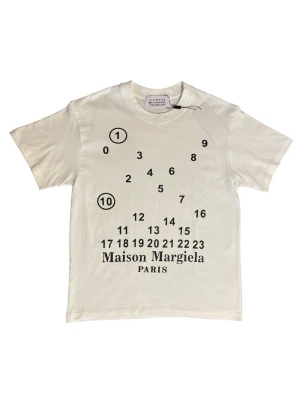 Maison Margiela T-shirt - Säljer denna fina helt oanvända vita tröjan med  MM6 tryck. Tröjan är i storlek S. Perfekt nu inför sommaren! Köpt från Vinted. Hör av er ifall ni har några frågor! ⚜️⭐️⛱️