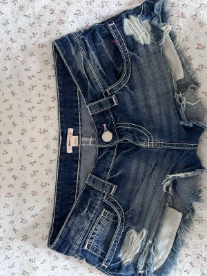 Blå slitna jeansshorts med fransar - Säljer ett par blå jeansshorts från Gina tricot. ☀️ Perfekta för sommaren! Bra skick