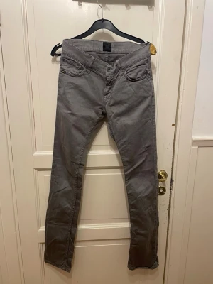 Gråa slim fit jeans från tiger of sweden  - Säljer ett par gråa slim fit jeans från tiger of sweden Jeans. Modellen har klassisk femficksdesign, normal midja och raka ben. Materialet är mjukt och stretchigt för extra komfort. Perfekta för dig som gillar en stilren och enkel look.