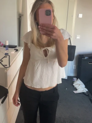 Vit topp - Söt vit topp från H&M i smockat material med korta volangärmar och knytning framtill. Materialet är lätt och stretchigt för extra komfort, den har används fåtal gånger💕