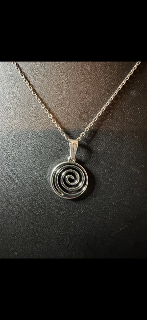 Silverhalsband med spiralberlock - Snyggt halsband i silverfärg med en spiralformad berlock. Kedjan är tunn och stilren, och spiralhänget ger ett coolt och modernt intryck. Perfekt för dig som gillar minimalistiska smycken med en twist. Materialet ser ut att vara metall.