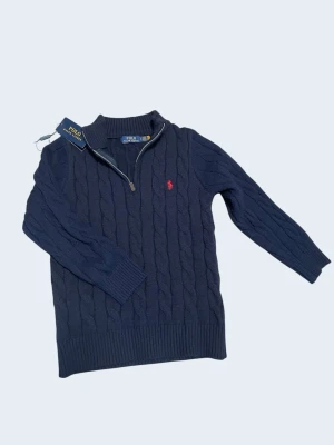  Polo Ralph Lauren half zip  - Mörkblå kabelstickad tröja från Polo Ralph Lauren med halv dragkedja och ribbade muddar. Tröjan har det klassiska röda Polo-logot broderat på bröstet och är tillverkad i mjukt material. Perfekt för en stilren och avslappnad look. Stl S mycket fint skick. Tags medföljer. Kan gå ner lite i pris vid snabb affär🤩