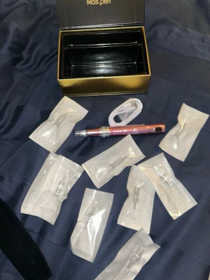 Maspen dermapen kit - Elektronisk microneedling penna från Maspen i metallicrosa med tillhörande laddkabel.