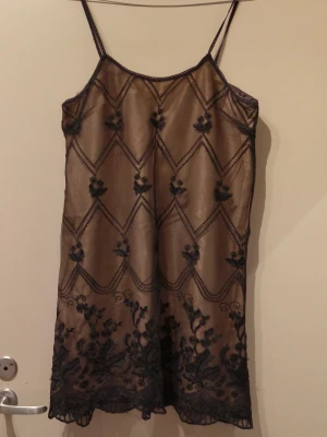 Svart spetsklänning från Hennes - Snygg klänning från Hennes collection i svart mesh med tunna axelband. Klänningen har broderade blommor och spetsdetaljer längs nederkanten. Materialet är tunt och genomskinligt, perfekt för en chic och bekväm känsla. Storlek appen är borta men jag tror det är en S