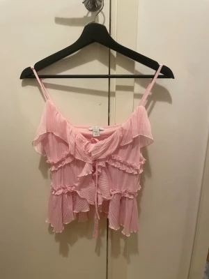 Ljusrosa volang topp med knyt - Supersöt ljusrosa linnetopp med tunna axelband