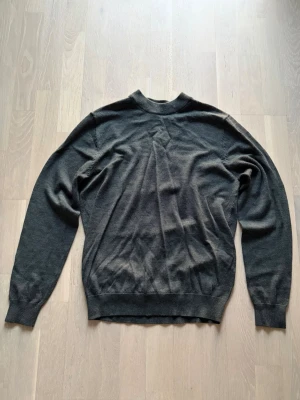 Mörkgrön stickad tröja från Cubus - Säljer en stilren mörkgrön stickad tröja med rund halsringning och långa ärmar från Cubus. Tröjan har ribbade muddar vid ärmslut och nederkant. Helt ny men utan prislapp. 