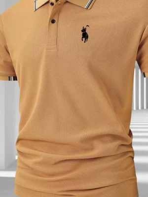 Beige pikétröja med broderad logga - Snygg beige pikétröja från Polo Ralph Lauren med klassisk krage, knappar och svart broderad logga på bröstet. Tröjan har korta ärmar och ribbade detaljer vid ärmslut och krage. Tillverkad i mjuk bomull för en bekväm känsla.