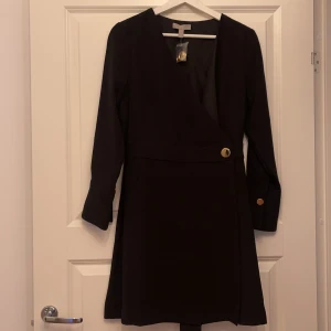 Klänning  - Enbart testad  Omlott  Knapp vid midjan  V-ringad Lårlång 