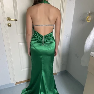 Balklänning  - säljer en grön balklänning med vinna stenar som delkoration.