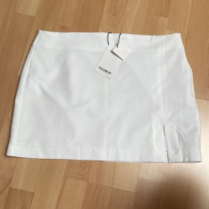 Vit kjol aldrig använd - Vit minikjol ifrån pull and bear. Kjolen har en liten slits på vänster sida. Aldrig använd. Prislappen sitter kvar. 