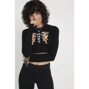 Crop top med tryck - En fin och unik tröja med långa ärmar från Urban Outfitters. Säljer på grund av att den inte kommer till användning. Storlek M men mer som en S. I fint skick!