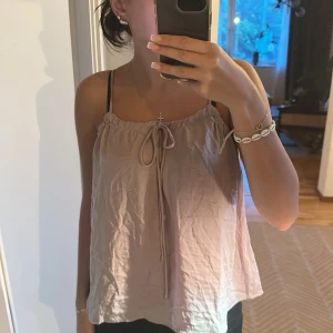 Söt topp - Jag säljer mitt rosa/beige linne från hm som är i ett lätt lunt tygg som antingen passar till en lite finare nattlinne eller en fest topp eller bara till vardags helt oanvänd prislapp på! Ord pris 199kr 