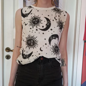 Linne med sol och måne - Vitt linne med svarta solar och månar, något genomskinligt och med stora ärmhål (se bild 2).