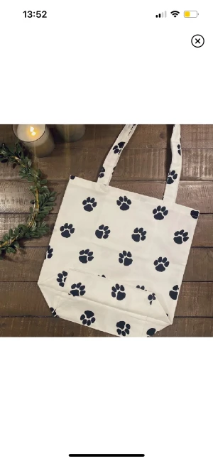 Tygpåse - Handsydd tygpåse med jättegulligt tassmotiv🥰 Påsen är i ett slitstark tyg och har måttet ca 34x 34cm och handtagen är ca 70cm långa så den kan bäras på axeln💞 