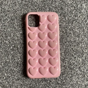 Mobilskal med 3D hjärtan  - Jätte gulligt rosa mobilskal för en IPhone 11 med 3D hjärtan. Köpt för 150kr. Säljer för 65kr, kan dock diskutera pris! 