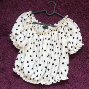 Prickig topp - Supersöt svart/vit prickig topp från gekås! Går att dra ner ärmarna så den blir off shoulder, och den är croppad. Stretchigt material ❤️🩵säljer pga Kmr ite till användning 🫶🩵från barnavdelningen. Oanvänd 