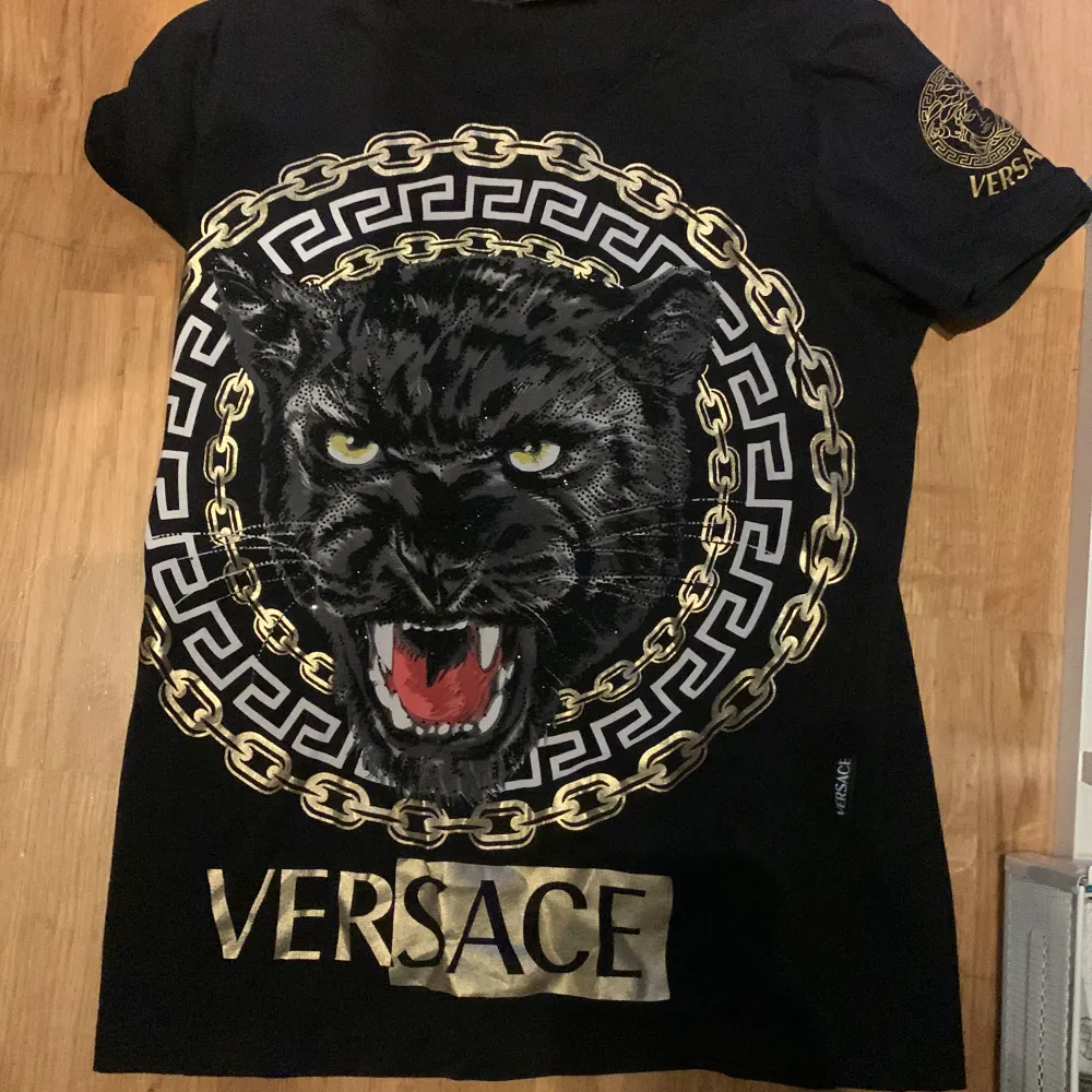 En svart Versace tshirt väldigt fin i bra skick . T-shirts.