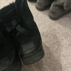 Svarta bailey bow - Uggs i använt skick med ett jätte litet hål framtill, går att fixa hos skomakare