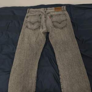 Ett par ljusgråa levi’s jeans som är i bra skick. Fått lite svart färg på märket från mitt bälte. Modell 551 sitter som vanliga 501