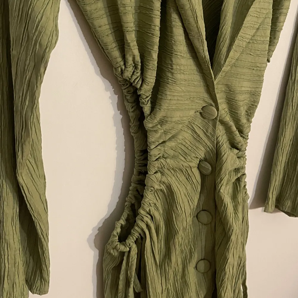 Helt oanvänd grön skjortklänning från Prettylittlething med cut outs på båda sidor som går att justera själv. Det är i storlek 8 (UK size) . Klänningar.