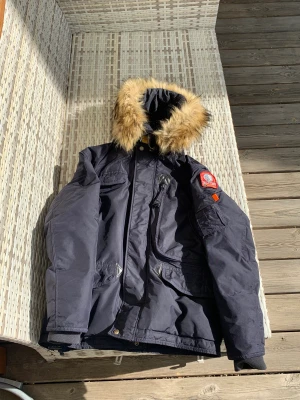 Parajumper vinterjacka  - Säljer min parajumper vinterjacka. Som har blivit för liten, skicket på jackan är utmärkt, inget fel eller skada på jackan. Pälsen är väldigt smidig att sätta på samt ta av. Med följer en loga som är svart, nypriset på jackan är 5699 kr.