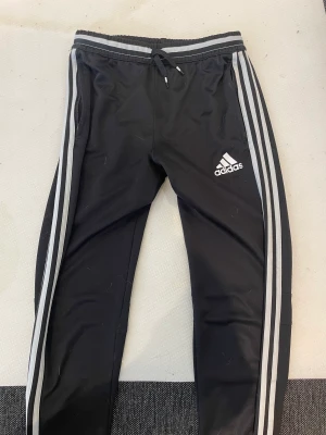 Adidas byxor  - Adidas byxor köpt 2018, använd mest i början och senaste 4 åren har dom enbart legat i lådan.  Står att dom är L men jag kan ha dom och jag brukar ha XS-M