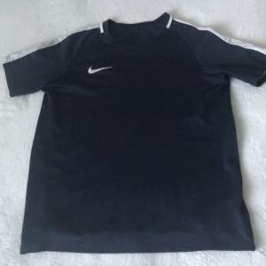 Mörkblå nike dri-fit tränings-T-shirt för 180kr. Storlek: 158-170 XL