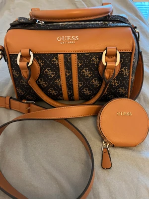 GUESS VÄSKA - En jätte fin och rymlig väska från Guess. Den är använd men den är i nyskick inga skador eller märken på väskan. Den köptes för 1400kr, Kvitto finns. Pris kan diskuteras 