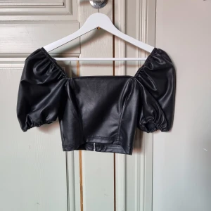 Lädertopp med puffärm - En jättesöt lädertopp från hm i storlek 32. Endast provad då jag tyvärr ganska snabbt växte ur den. Dragkedja där bak. Originalpris 150 kr när den inköptes🌸💖