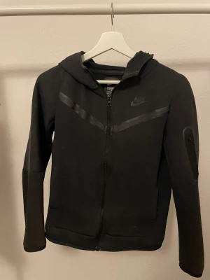 Svart Nike tech! - Säljer en svart Nike tech kofta, använd men i jätte bra skick. Köpt för 800 men kan sälja för 500 (priset kan diskuteras också)